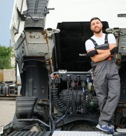 Semi Truck Maintenance. Caucasian Truck Service Worker in His 30s Performing Scheduled Recall Maintenance